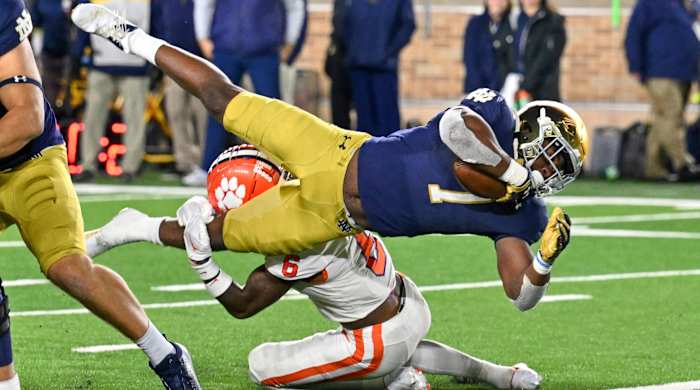 Audric Estimé breaks through a tackle.